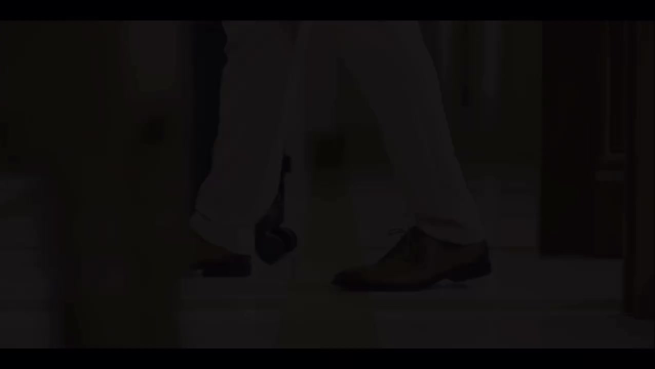 A suitcase rolls across a marble floor