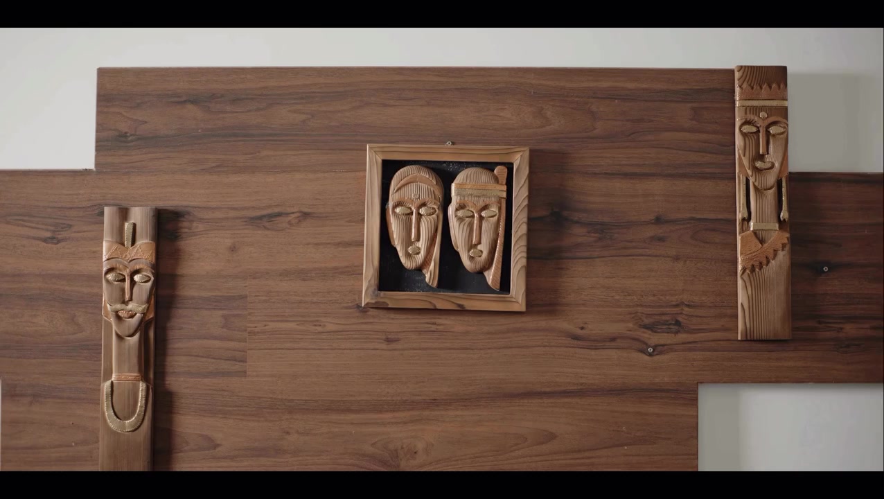 Carved wooden masks on a warm timber wall