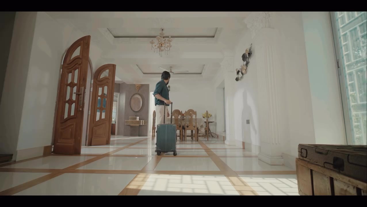 A man arrives in a bright, empty hallway